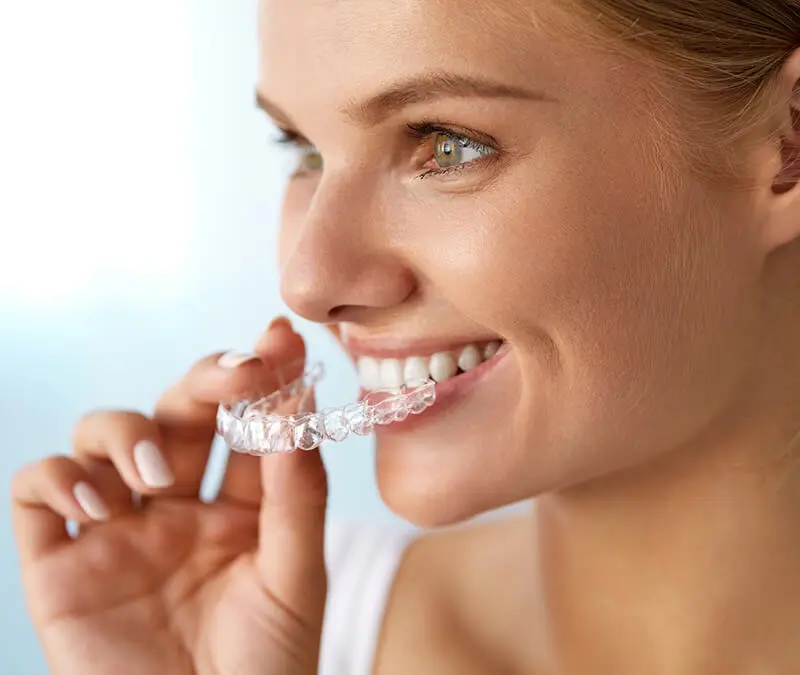 Patient wearing clear aligners at Conklin Family Dental while dentist explains SureSmile orthodontic treatment plan